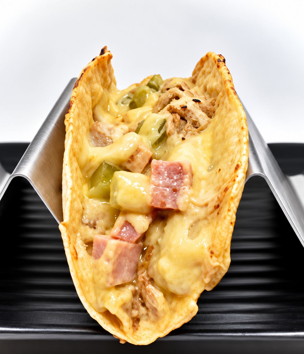 Cuban-inspired taco with pulled pork, ham, swiss cheese and pickles